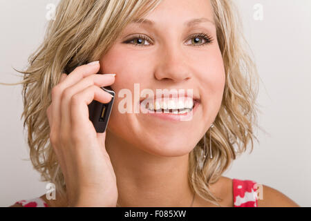 Junge blonde Frau reden über ihr Handy Stockfoto
