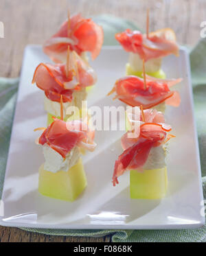 Schinken, Käse und Melone auf Platte Stockfoto