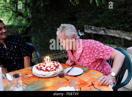 Mann in seinen 50er Jahre feiert seinen Geburtstag Ausblasen der Kerzen auf der Torte Stockfoto