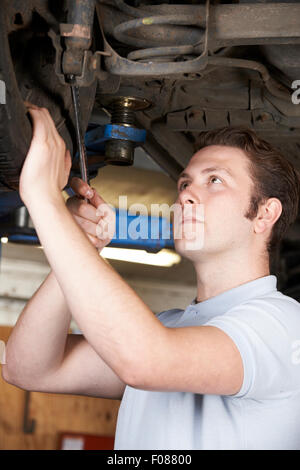 Mechaniker arbeiten am Rad unter Wagen Stockfoto