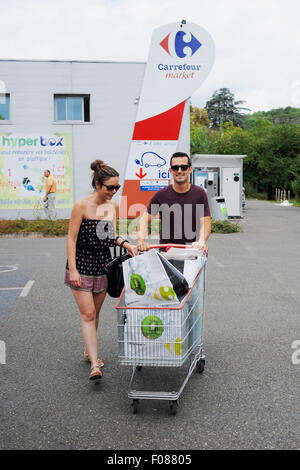 Junges Paar Einkaufen im Carrefour-Supermarkt in Prayssac schieben Wagen mit Lebensmitteln - Frankreich Stockfoto