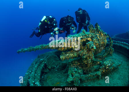 Rebreather Taucher erkunden das Geschütz am Bug der LST 349 Wrack, Ponza, Italien Stockfoto