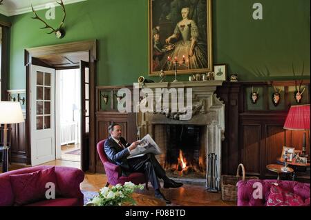 Andreas Graf von Brühl-Pohl sitzt in der Nähe von Kamin im Schloss Neuschwanstein, Sachsen Stockfoto