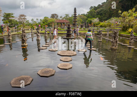 Besucher, die auf steinernen Spuren im Tirta Gangga Wasserpalast in Karangasem, Bali, Indonesien, spazieren. Stockfoto