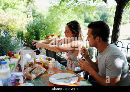 Junges Paar Essen und frisches zubereitetes Frühstück im Freien auf Sommertag auf ihren Urlaub-Ferienhaus in der Region von Frankreich viel Auswahl Stockfoto