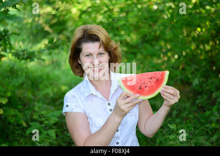 Frau mit einer Scheibe Wassermelone in der Natur Stockfoto