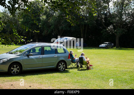 Zwei alte Leute, die mit einem Picknick mit ihrem Auto auf Severn Park, Bridgnorth, Shropshire, England, UK Stockfoto