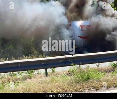 Manchester, UK. 10. August 2015. M56 /Chester Manchester hat Montag, 10. August 2015 lodernden Tanker auf Chester gebundene Fahrbahn der M56 die Autobahn in beide Richtungen geschlossen.  Der LKW auf dem Standstreifen zwischen J14 bei Hapsford und Kreuzung 15 an der M53 ist und ein 1500 m Kordon wurde eingerichtet.  Aus ihren Fahrzeugen und in sicherer Entfernung verschoben werden Autofahrer darin evakuiert.  Verkehr wird angeblich von Daresbury und an einem Stand noch gesichert. Bildnachweis: Jason Kay/Alamy Live News Stockfoto