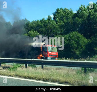 Manchester, UK. 10. August 2015. M56 /Chester Manchester hat Montag, 10. August 2015 lodernden Tanker auf Chester gebundene Fahrbahn der M56 die Autobahn in beide Richtungen geschlossen.  Der LKW auf dem Standstreifen zwischen J14 bei Hapsford und Kreuzung 15 an der M53 ist und ein 1500 m Kordon wurde eingerichtet.  Aus ihren Fahrzeugen und in sicherer Entfernung verschoben werden Autofahrer darin evakuiert.  Verkehr wird angeblich von Daresbury und an einem Stand noch gesichert. Bildnachweis: Jason Kay/Alamy Live News Stockfoto