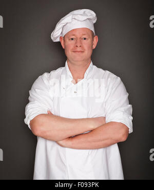 Männlichen Chef Stand mit verschränkten Armen Studioportrait Stockfoto