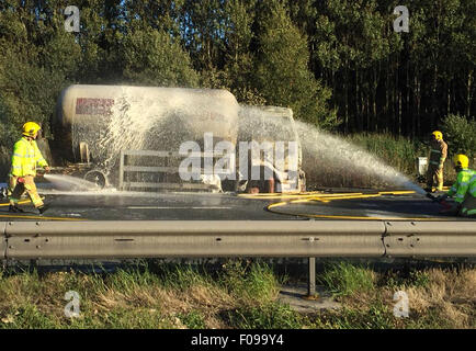 Manchester, UK. 10. August 2015. M56 /Chester Manchester hat Montag, 10. August 2015 lodernden Tanker auf Chester gebundene Fahrbahn der M56 die Autobahn in beide Richtungen geschlossen.  Der LKW auf dem Standstreifen zwischen J14 bei Hapsford und Kreuzung 15 an der M53 ist und ein 1500 m Kordon wurde eingerichtet.  Aus ihren Fahrzeugen und in sicherer Entfernung verschoben werden Autofahrer darin evakuiert.  Verkehr wird angeblich von Daresbury und an einem Stand noch gesichert. Bildnachweis: Jason Kay/Alamy Live News Stockfoto