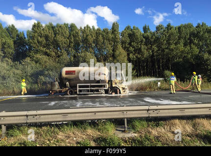 Manchester, UK. 10. August 2015. M56 /Chester Manchester hat Montag, 10. August 2015 lodernden Tanker auf Chester gebundene Fahrbahn der M56 die Autobahn in beide Richtungen geschlossen.  Der LKW auf dem Standstreifen zwischen J14 bei Hapsford und Kreuzung 15 an der M53 ist und ein 1500 m Kordon wurde eingerichtet.  Aus ihren Fahrzeugen und in sicherer Entfernung verschoben werden Autofahrer darin evakuiert.  Verkehr wird angeblich von Daresbury und an einem Stand noch gesichert. Bildnachweis: Jason Kay/Alamy Live News Stockfoto