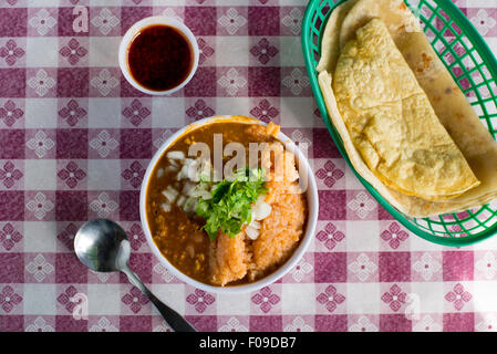 Draufsicht auf Taco Komponenten: Reis, Bohnen und Schweinefleisch in einer kleinen Schüssel; Tacos; und Salsa. Stockfoto