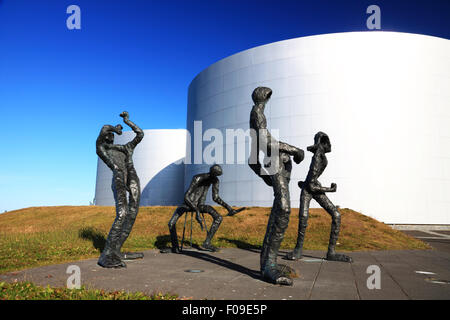 Eine Gruppe von Bronze Figuren darzustellen Musiker neben einer Gruppe von Metall Lagertanks. Stockfoto