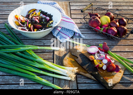 Linsensuppe und Obstsalat auf einem Holztisch Garten vorbereiten Stockfoto