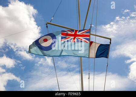 RAF-Ensign Fahne auf Vollmast gegen blauen Himmel.  Französische Flagge in Ferne Stockfoto