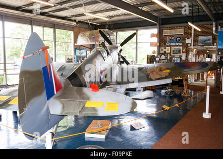 Innenraum der Spitfire und Hurricane Memorial Museum in Manston, Kent. Ein Supermarine Spitfire Mk XVI (LF) mit verschiedenen Exponaten herum angeordnet. Stockfoto