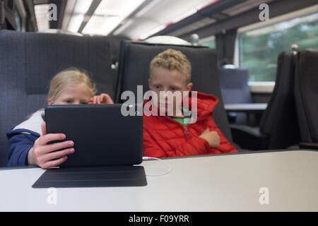 Kinder die Zeit zu vertreiben, auf einem Ipad auf einem Chiltern Railways Zug UK Stockfoto