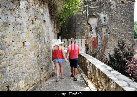 Junges Paar gehen Hand in Hand im Urlaub durch Puy l'Eveque in der Region Midi-Pyrenäen in Frankreich Stockfoto