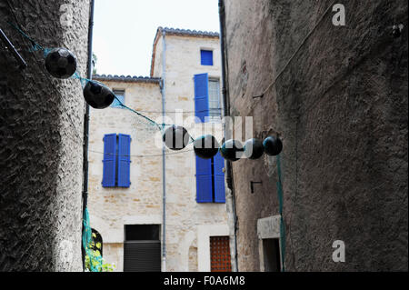 Streetart von Fußbällen hing zwischen den engen Gassen von Puy-l'ƒv Que befindet sich eine kleine Stadt in Frankreich im Département Lot mit Stockfoto