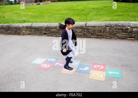 Mädchen spielen Himmel und Hölle auf Spielplatz Stockfoto