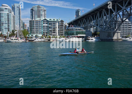 Zwei Frau Kajakfahren in False Creek in Vancouver, von der Granville Bridge. Yaletown Eigentumswohnungaufsätzen entlang der Uferpromenade. Stockfoto