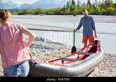 Paar mit Beiboot zu Wasser mit Paddel Stockfoto