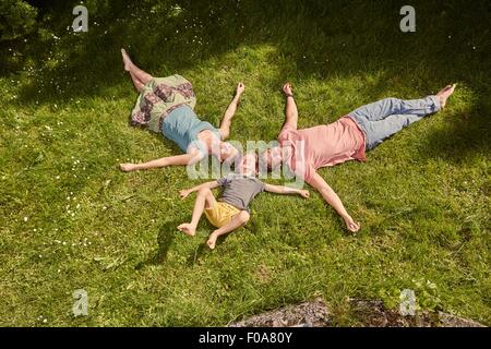 Mutter, Vater und Sohn, im Garten, auf dem Rasen liegen, relaxen Stockfoto