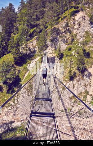 Reife Frau Wandern, aufwachen entlang Seilbrücke, Rückansicht, Karwendel Mittenwald, Bayern, Deutschland Stockfoto