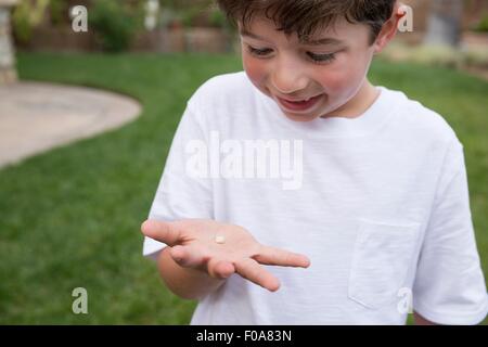 Kleiner Junge hält Zahn in der hand Stockfoto