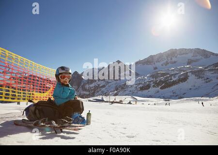 Porträt des jungen Skifahrer sitzen auf Rucksack Essen Snack, Neustift, Stubaital, Tirol, Österreich Stockfoto