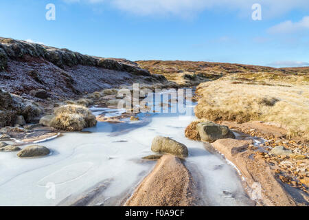 Eine gefrorene Stream auf Torfgebiete im Winter. Edale Moor, Kinder Scout, Derbyshire Peak District National Park, England, Großbritannien Stockfoto