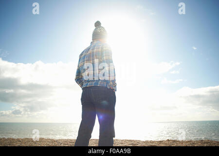 Reifer Mann, Blick auf das Meer vom Strand Stockfoto