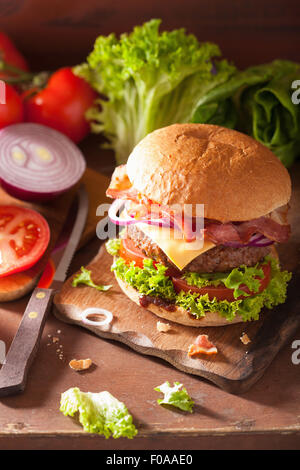 Kochen Speck Käse Burger mit Rindfleisch Patty Tomate Zwiebel Stockfoto