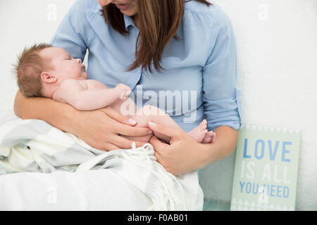 Mutter wiegt Baby in armen Stockfoto