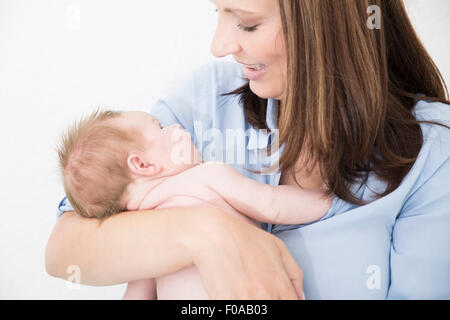 Mutter wiegt Baby in armen Stockfoto