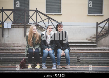 Drei Schwestern sitzen auf der Parkbank Stockfoto