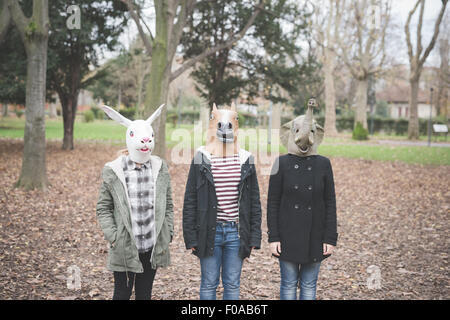 Drei Schwestern tragen Tiermasken posiert im park Stockfoto