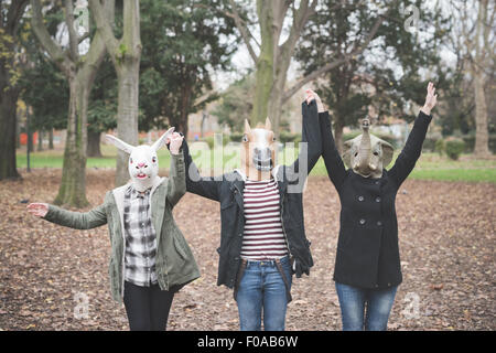 Drei Schwestern tragen Masken tanzen im park Stockfoto