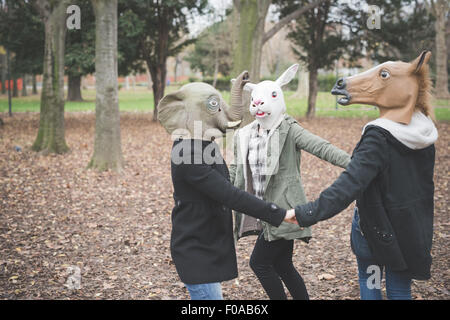 Drei Schwestern tragen Masken tanzen im park Stockfoto