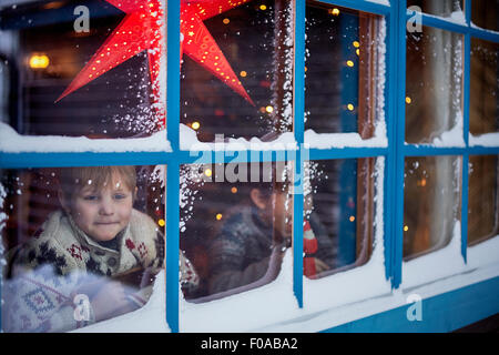 Zwei Brüder suchen aus Kabinenfenster zu Weihnachten Stockfoto