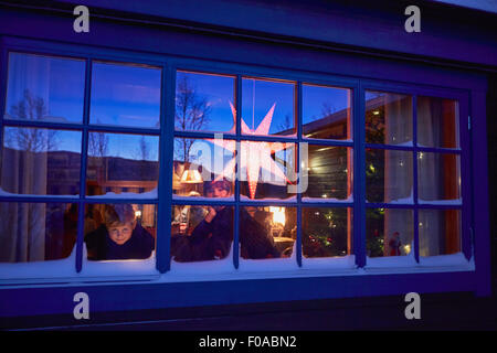 Zwei Brüder suchen aus der Kabine-Weihnachts-Fenster in der Nacht Stockfoto