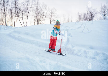 Junge auf Schnee-Scooter bewegen bergab, Hemavan, Schweden Stockfoto