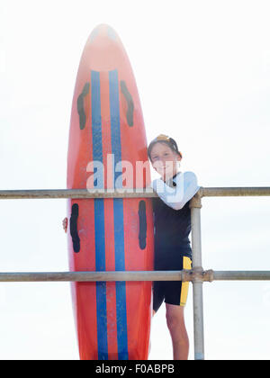 Porträt des jungen Nipper (Kind Surf Life Savers) gelehnt Geländer, Altona, Melbourne, Australien Stockfoto