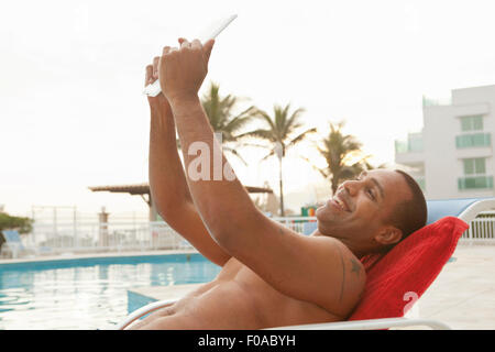 Mitte erwachsenen Mann unter digital-Tablette Selfie am Hotel Pool, Rio De Janeiro, Brasilien Stockfoto