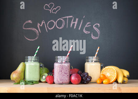 Stillleben mit drei frische Smoothies vor Tafel Stockfoto