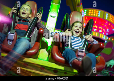 Schwester und Bruder am Messegelände fahren in der Nacht Stockfoto