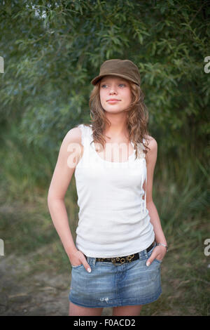 Porträt der jungen Frau tragen Kappe mit Händen in den Taschen Stockfoto