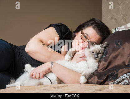 Porträt von Ragdoll Katze mit Besitzer, entspannen Sie sich auf Bett Stockfoto