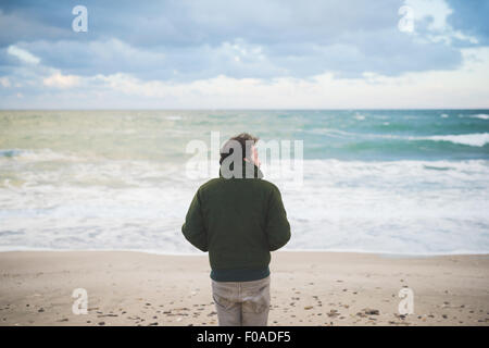 Rückansicht des Mannes blickt seitlich auf windiger Strand, Sorso, Sassari, Sardinien, Italien Stockfoto